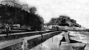 A train passes the sea wall at Gorey