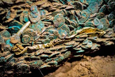 A strip of gold running across the block in the centre of this picture alerted conservators to the presence of gold torques among the coins