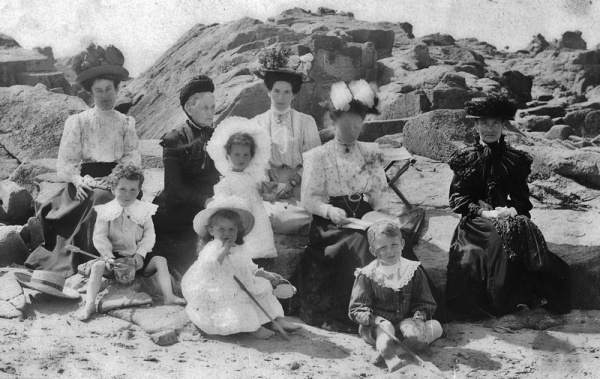 A well-to-do family poses for a photograph on the beach in the 19th century