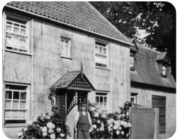 Head Gardener`s Cottage, with the Head Gardener, Mr Boobyer, at the door
