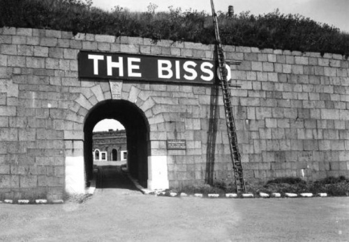 These photographs of the main archway to the Fort Regent parade ground were taken in the 1930s. They show a sign being erected for the Bisson School Boys Club which was organised at the Fort from 1932 to 1939 to provide a holiday camp for underprivileged children from England.
