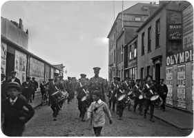 A military band marches along Conway Street from the Esplanade