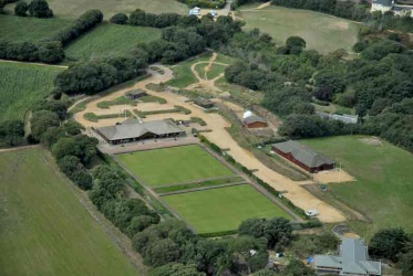 Les Creux Bowls club in 2006 with the neighbouring white dome and shed of the Jersey Astronomy Club. The other large building below the astronomy club is the headquarters of the 10th St Brelade Scout Group. The field at the top of the picture next to the small hoggin car park is now allotments.