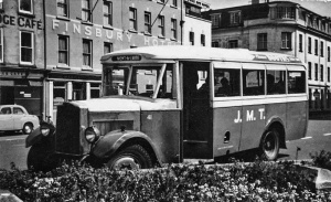 A single decker JMT bus waiting at the Weighbridge in front of the Finsbury Hotel