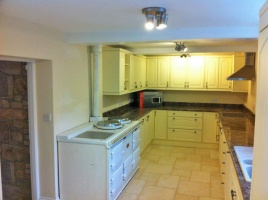 The modern kitchen in a single storey extension at the rear