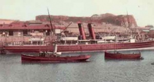 A large passenger steamer docks in St Helier with the help of a tug