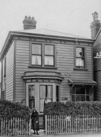 Christina Picot, daughter of John, born in Jersey in 1860, and Isabella, nee Simpson (1857-1931) in front of the family home in New Zealand