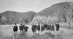 A group of Edwardian men on an outing paddle in the sea
