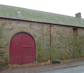 The round roadside arch of an outbuilding which gives the property its name