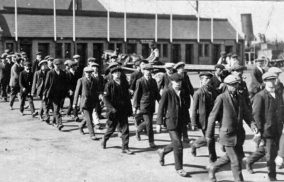 After the Regular British Army garrison left soon after the war’s start, the War Office sent a unit of the South Staffordshire Regiment to Jersey. The 4th (Special Reserve) Battalion was a training unit, preparing new soldiers for despatch as reinforcements for the regiment’s active service battalions. Soon it was receiving hundreds of recruits, men raised through Lord Kitchener’s ‘Your Country Needs You’ campaign. This image shows a batch arriving on the New North Quay, probably in the autumn of 1914, without uniforms or equipment.