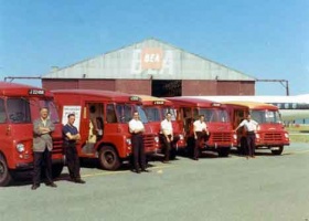 Post vans wait in front of the main hangar
