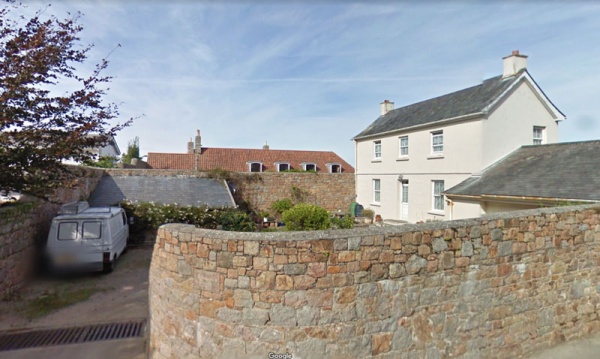 The view from the roadside in 2010. The red roofs in the background may be the buildings shown in the 100-year-old black and white photograph above