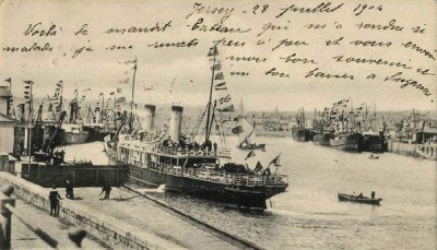 Flags and bunting in St Helier Harbour on 2 June 1902 to mark the end of the South African war. Still being used as a postcard two years later