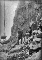 Quarry workers cut stone from a granite face