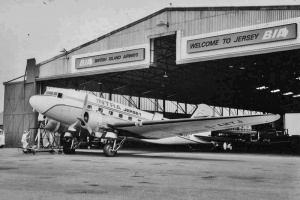 An Intra Airways Dakota, one of seven owned by the airline in the 1970s, being worked on in front of a hangar at Jersey Airport