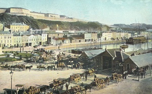 Horse-drawn vans laden with potatoes queue before the weighbridge in 1907