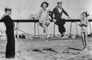 Visiting sailors and local girls have fun on the beach in 1935
