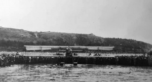 The first plane to land in Jersey, taken from the sea with a large crowde behind, and West Park in the background
