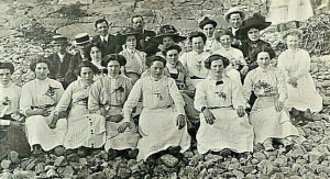 A large group poses for a photograph on the beach in 1910 - who and where are not known