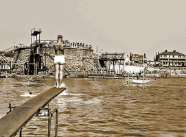 A diver on a springboard opposite the main diving tower