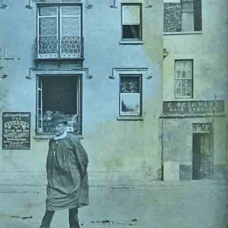 lThe board on the left advertises the aquarium at Havre des Pas, and to the right is hairdresser C de la Haye's premises. The smock and hat worn at a jaunty angle by the man in the foreground give no real clue to the age of the photograph