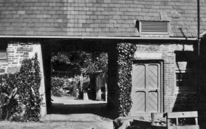 View looking northwards from the Grange, to the Stables (left) and Guy de Gruchy`s Engine Room (right), with "GFB dGC 1916" engraved upon the lintel; taken in the 1920s