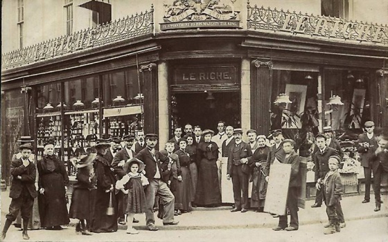 The staff, and perhaps some of their customers, pose outside the shop, after the property was rebuilt
