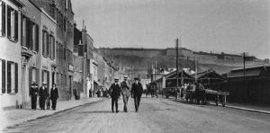 An unusual picture from the Edwardian era. Were the three gentlemen strolling happily along the middle of the road - that would never happen today - connected to the three ladies on the pavement?