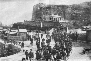 The 1st Battalion of the Devon Regiment parades on the pier ready for departure