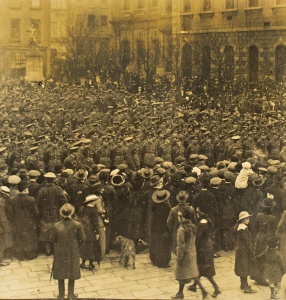 Jersey Contingent members assemble in the Royal Square on 2 March 1915, prior to marching to the harbour at 7.00 am. A large crowd of well-wishers have gathered under rather dreary conditions to bid them farewell and good luck.