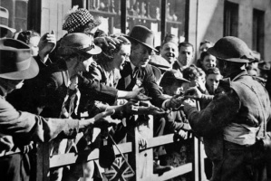 Soldiers offering cigarettes to liberated islanders